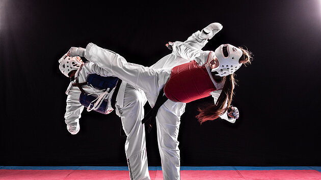 Junger Mann und Frau im Taekwondo-Kampf. Kampf zweier Schwarzgurte